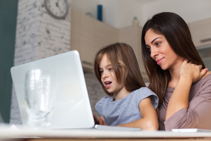 Girl and mother using laptop